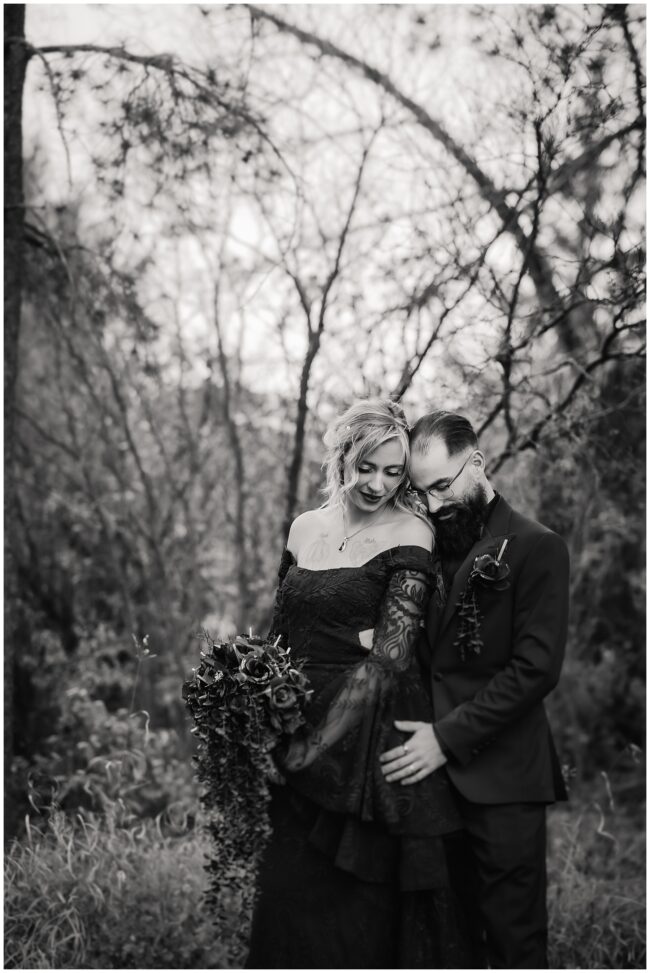 black and white image of bride and groom on wedding day. bride wearing black lace dress