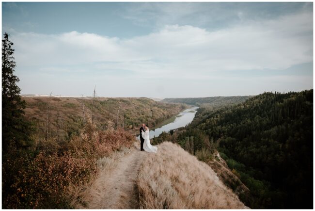 bride and groom in classic wedding attire. breathtaking views of the river behind them